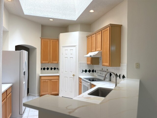 kitchen featuring white appliances, sink, tasteful backsplash, and light tile patterned floors