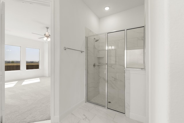 bathroom with ceiling fan and a shower with shower door