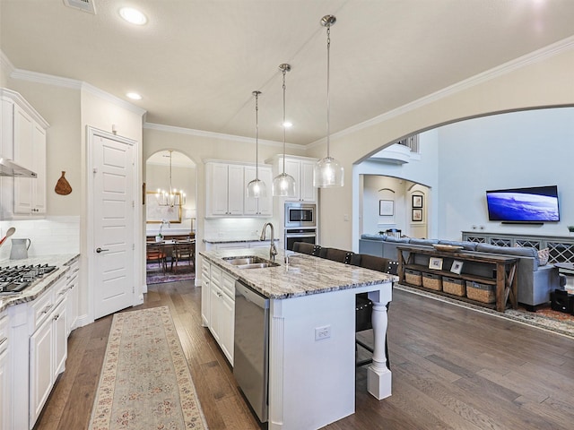 kitchen with sink, an island with sink, stainless steel appliances, and dark hardwood / wood-style floors