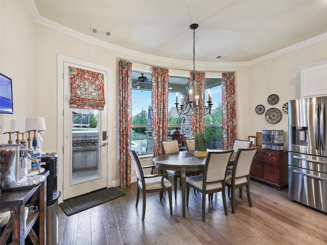 dining space with wood-type flooring, a wealth of natural light, and ornamental molding