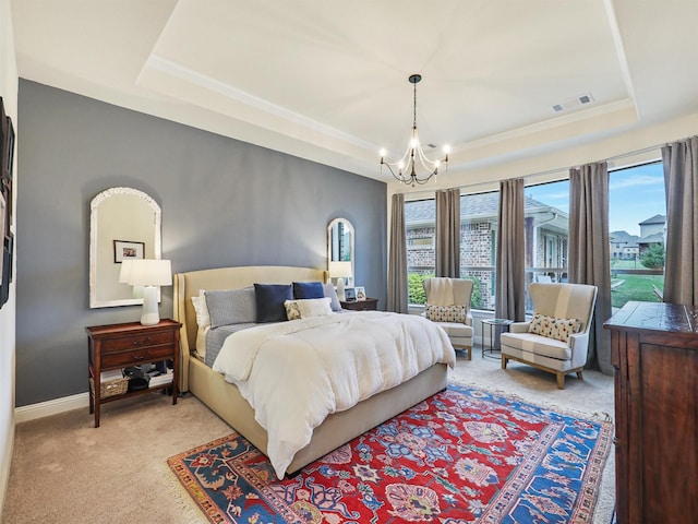 carpeted bedroom with a tray ceiling, multiple windows, and a notable chandelier