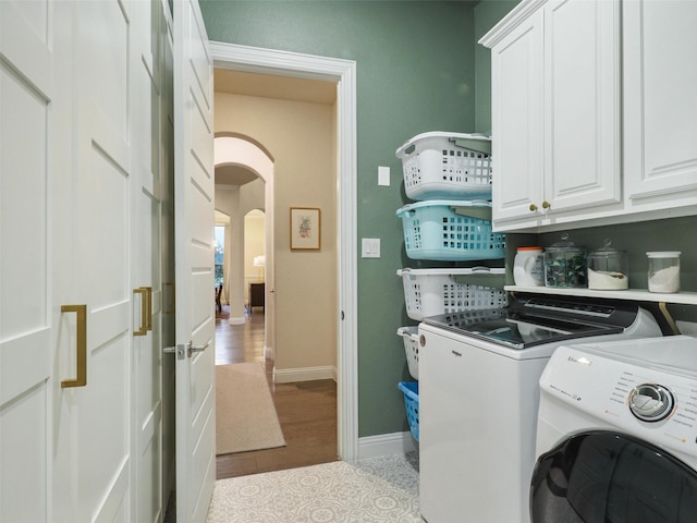 washroom with cabinets, light tile patterned floors, and washer and dryer