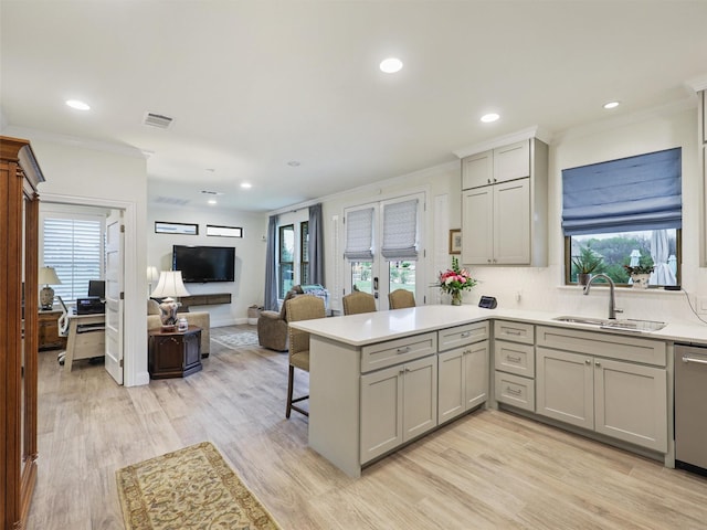 kitchen with kitchen peninsula, gray cabinetry, a healthy amount of sunlight, sink, and light hardwood / wood-style floors