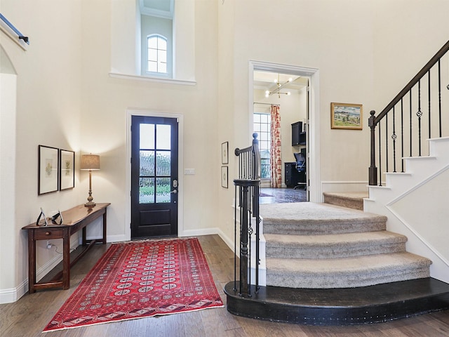 entrance foyer featuring hardwood / wood-style floors, a towering ceiling, and plenty of natural light