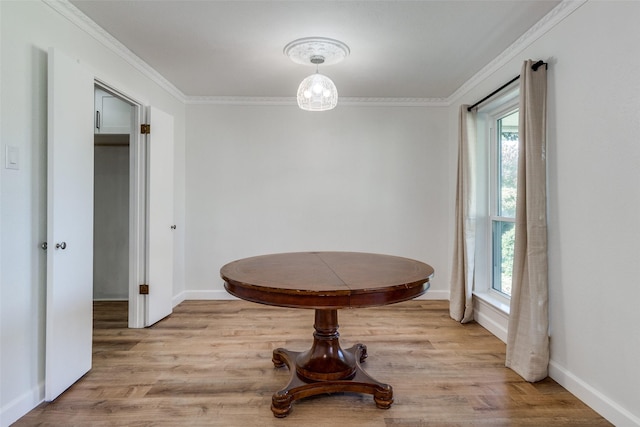 dining space with plenty of natural light, ornamental molding, and light hardwood / wood-style flooring