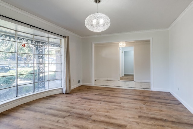 empty room featuring a chandelier, light hardwood / wood-style flooring, a healthy amount of sunlight, and ornamental molding