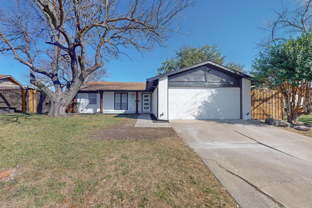 ranch-style home with a garage and a front lawn