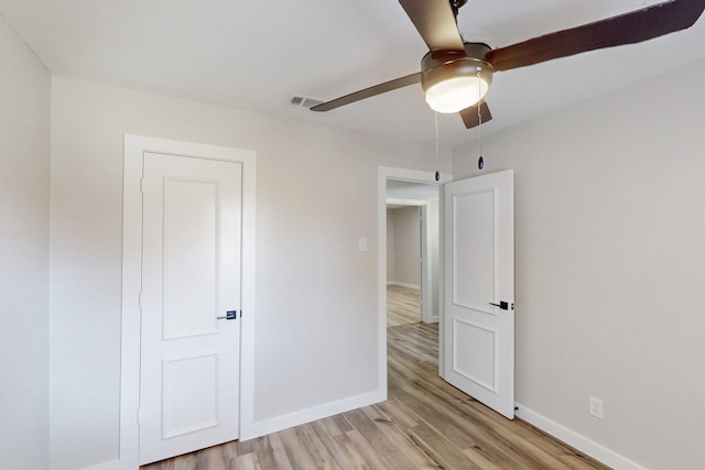 unfurnished bedroom featuring light wood-style flooring, visible vents, ceiling fan, and baseboards