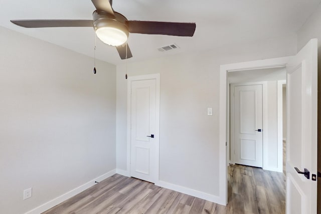 unfurnished bedroom with a ceiling fan, light wood-type flooring, visible vents, and baseboards