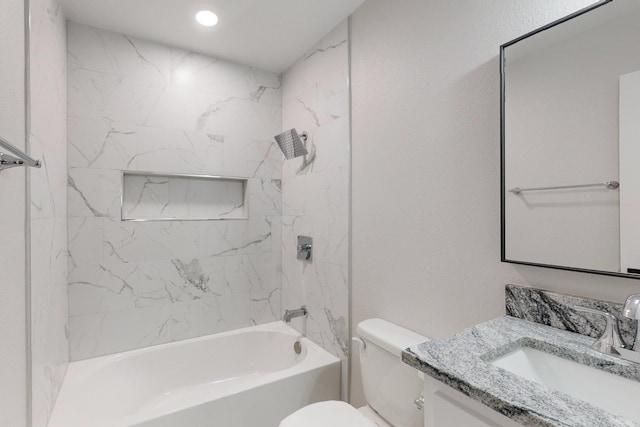 bathroom featuring a textured wall, tub / shower combination, vanity, and toilet