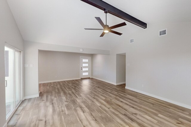 spare room featuring light wood-type flooring, visible vents, and beamed ceiling