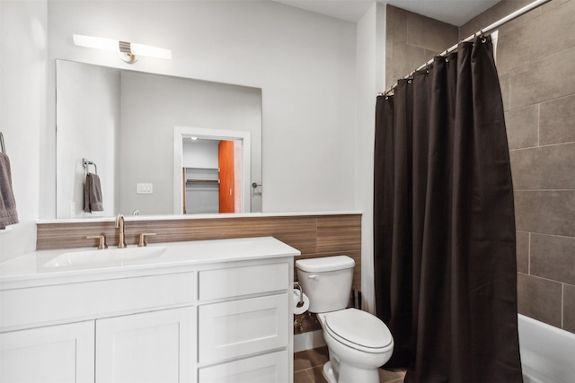 bathroom featuring a shower with curtain, toilet, vanity, and tile walls