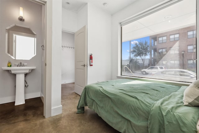 bedroom with concrete flooring and baseboards