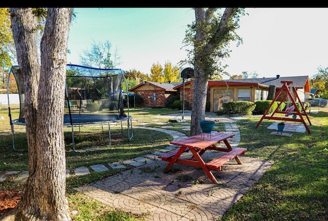 view of yard with a playground, a trampoline, and a patio area