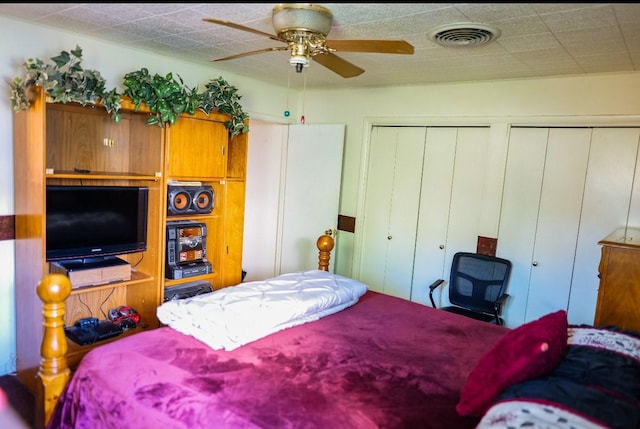 bedroom featuring ceiling fan and multiple closets