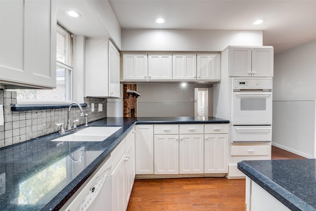 kitchen featuring white cabinetry, white appliances, and sink