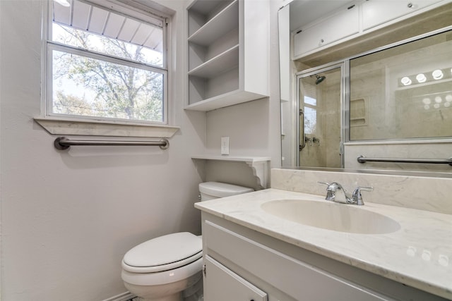 bathroom with vanity, toilet, and a shower with door