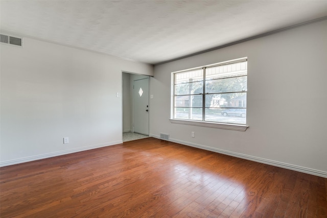 unfurnished room with wood-type flooring and ornamental molding