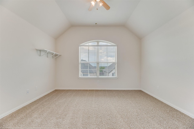 carpeted spare room with vaulted ceiling and ceiling fan