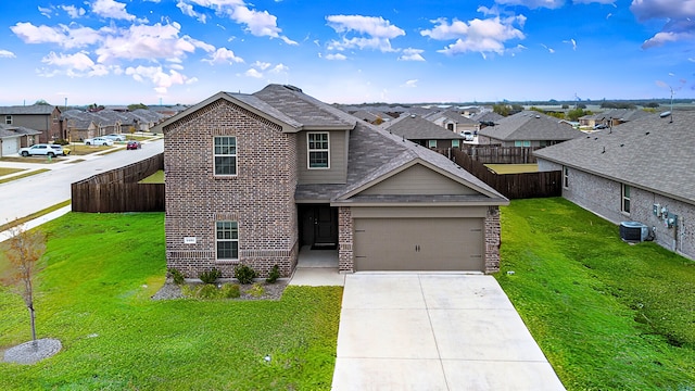 view of front of property featuring a front yard, a garage, and central AC unit