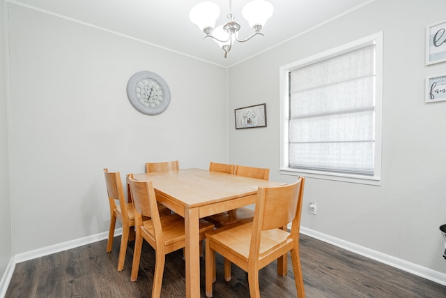 dining area with dark hardwood / wood-style flooring, ornamental molding, and a notable chandelier