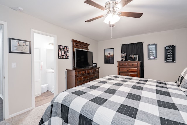 bedroom with light colored carpet, ensuite bath, and ceiling fan