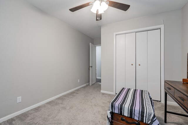 unfurnished bedroom featuring ceiling fan, light colored carpet, and a closet