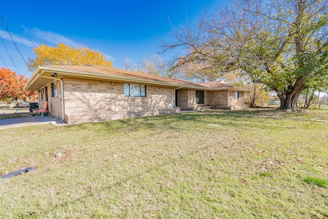 ranch-style home featuring a front yard and central air condition unit