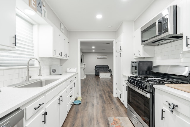 kitchen featuring sink, tasteful backsplash, dark hardwood / wood-style floors, white cabinets, and appliances with stainless steel finishes