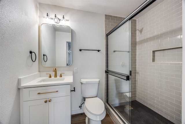 bathroom with hardwood / wood-style floors, vanity, and an enclosed shower