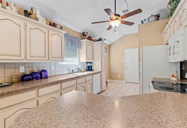 kitchen with tasteful backsplash, white appliances, sink, cream cabinets, and lofted ceiling