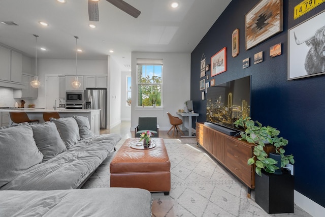 living room with ceiling fan, light hardwood / wood-style flooring, and sink