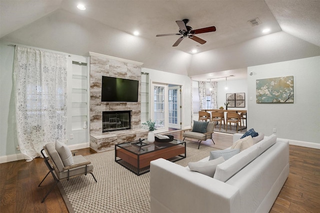 living room with lofted ceiling, a tiled fireplace, wood finished floors, and baseboards