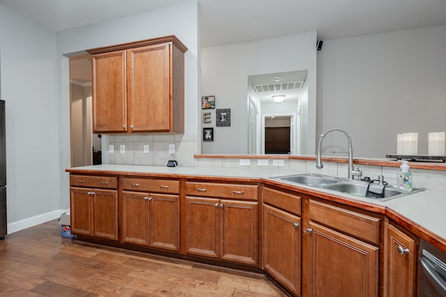 kitchen featuring light wood-type flooring, sink, and tasteful backsplash