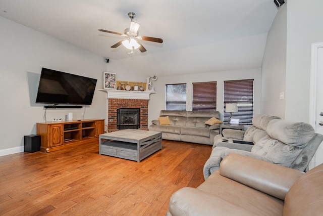 living room with ceiling fan, light hardwood / wood-style floors, and vaulted ceiling