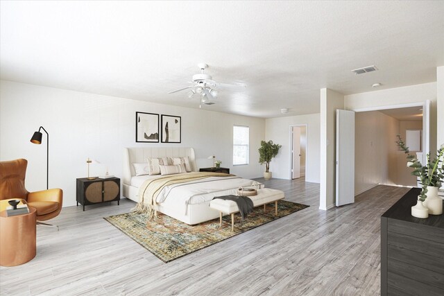 bedroom with a textured ceiling, light hardwood / wood-style floors, and ceiling fan