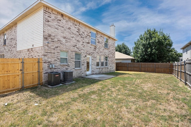 rear view of house with a lawn, a patio area, and central air condition unit