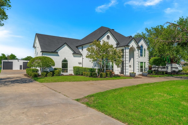 view of front of property with a front yard, a garage, and an outdoor structure