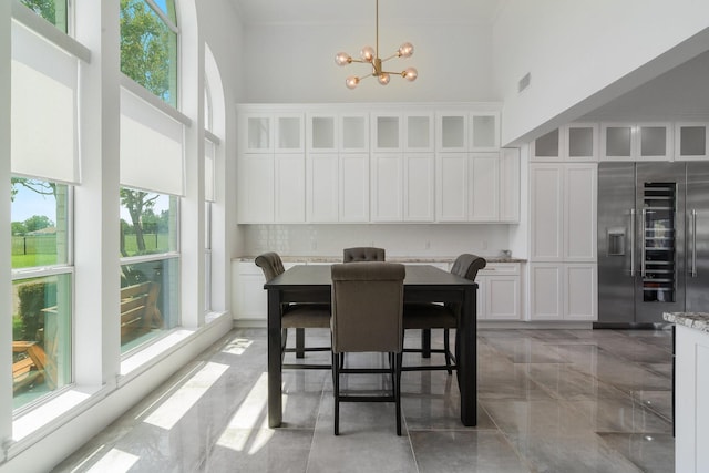 dining space with a chandelier and a high ceiling