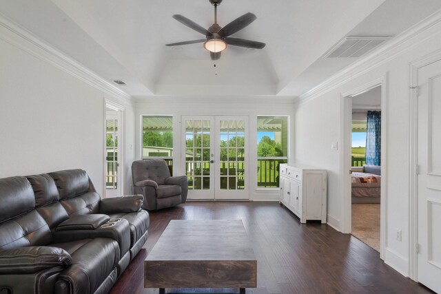 living room with plenty of natural light, a raised ceiling, and french doors