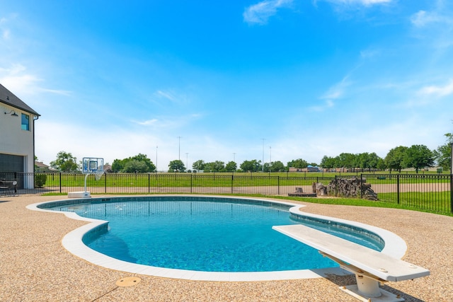 view of swimming pool with a diving board