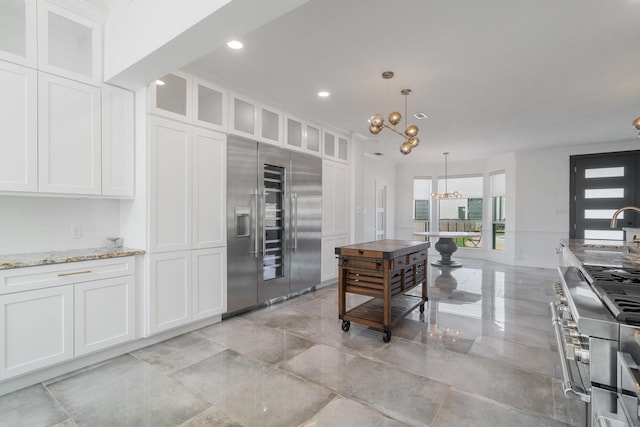 kitchen with a chandelier, white cabinetry, hanging light fixtures, and high quality appliances