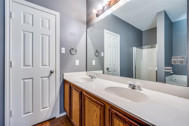 bathroom with hardwood / wood-style flooring, vanity, and a shower