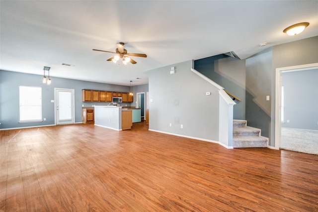 unfurnished living room featuring ceiling fan and light wood-type flooring