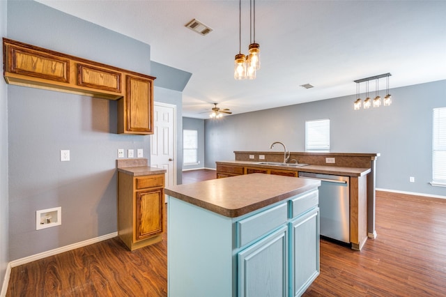 kitchen with ceiling fan with notable chandelier, sink, decorative light fixtures, dishwasher, and a center island