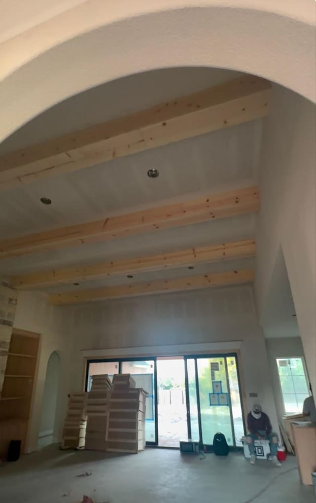 unfurnished living room with concrete flooring and beam ceiling