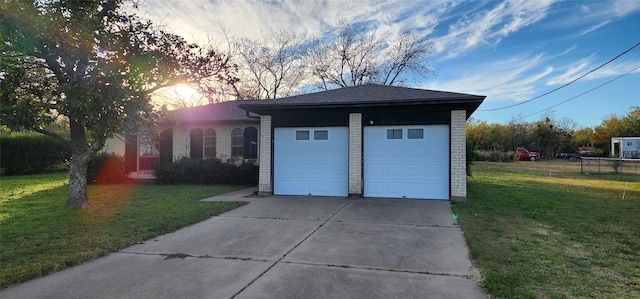 garage at dusk featuring a lawn