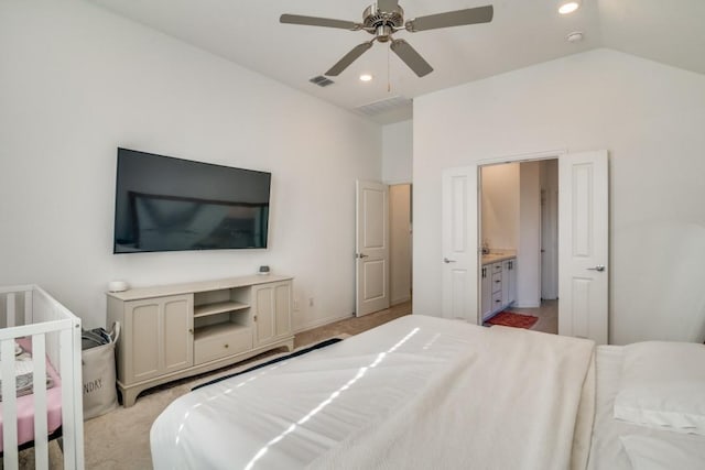 bedroom with connected bathroom, ceiling fan, light carpet, and lofted ceiling