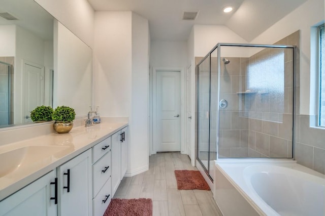 bathroom with vanity, separate shower and tub, and vaulted ceiling