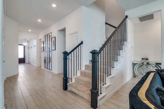 stairway featuring a chandelier and hardwood / wood-style flooring